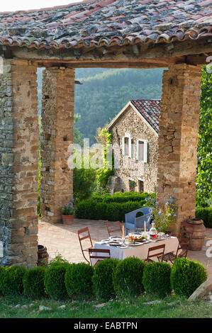 La tabella prevista per il pasto sul patio coperto di agriturismo nelle colline umbre Foto Stock