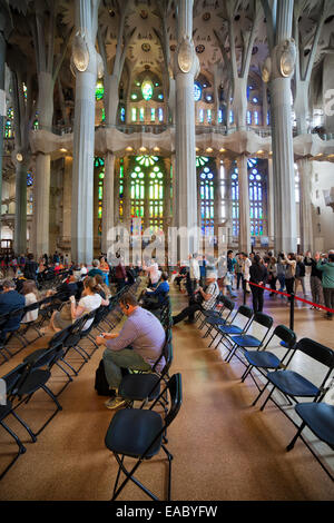 Le persone sedute a sdraio la Sagrada Familia basilica di Barcellona, in Catalogna, Spagna. Foto Stock