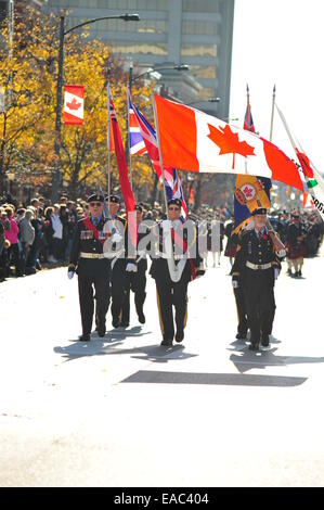 London, Ontario, Canada. 11 Novembre, 2014. Il passato e il presente dei membri della Canadian servizi armati e i membri del pubblico a raccogliere il cenotafio in London, Ontario per osservare il giorno del ricordo. Su questo pubblico su tutto il territorio nazionale per le vacanze europee tenere cerimonie a pagare rispetto ai caduti. Credito: Jonny bianco/Alamy Live News Foto Stock