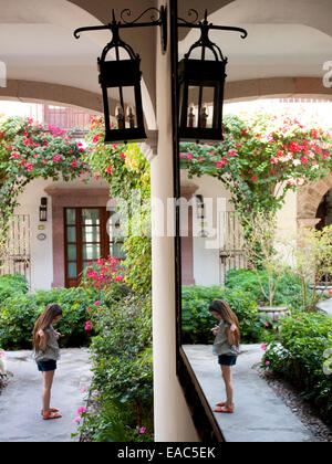 Giovane ragazza in giardino con specchio hall Foto Stock