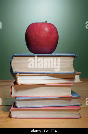 Apple sulla sommità di una pila di libri Foto Stock