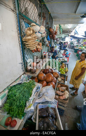 Stand di mercato che vende prodotti, cestini, e zucche decorative essiccate con le donne maya proprietario che indossa un vestito giallo di smock e polka-dot, Campeche MX Foto Stock