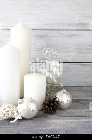 Candele bianche con le palle di Natale e il decor cervi sulle schede, xmas Foto Stock