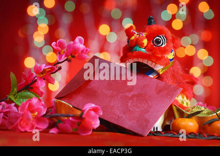 Anno Nuovo Cinese festival decorazioni, miniatura dancing lion e ang pow o pacchetto di rosso con spazio copia pronta per il testo su glitt Foto Stock