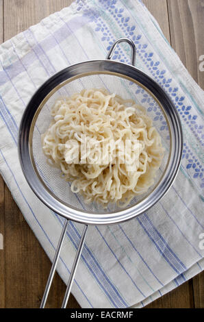 Tagliatelle istante in un setaccio e un asciugamano da cucina Foto Stock