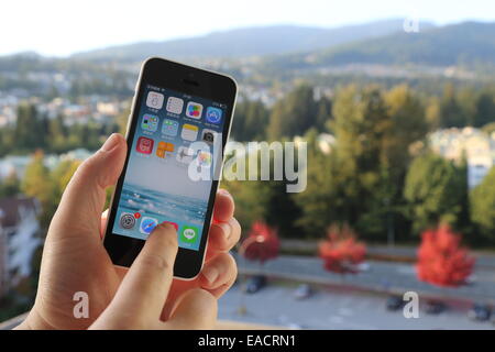 Coquitlam BC Canada - Ottobre 06, 2014 : Ricerca di musica su iPhone con la natura sfondo, IPhone è uno dei più popolari sma Foto Stock