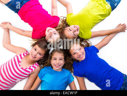 Capretto felice amico gruppo di ragazze sorridenti vista aerea che giace sul cerchio su sfondo bianco tenendo le mani Foto Stock