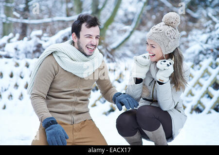 Coppia felice ridere insieme in inverno la neve all'aperto Foto Stock
