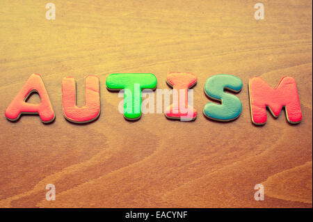 Parola autismo scritto con colorati i bambini le lettere magnetiche Foto Stock