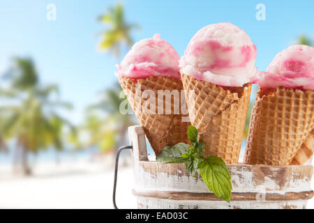 Gelato di frutta con blur spiaggia come sfondo. Servita su tavole di legno Foto Stock