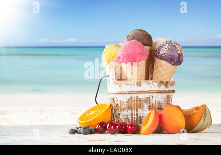 Set di vari tipi di frutta gelato sul ponte di legno con il mare di sfocatura sullo sfondo Foto Stock