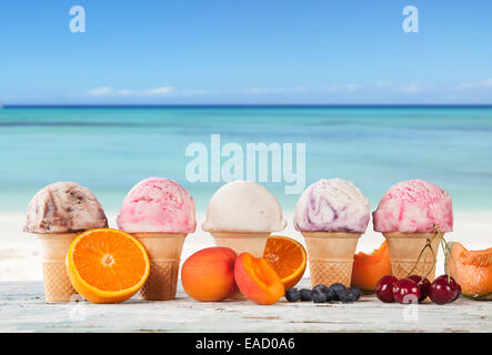 Set di vari tipi di frutta gelato sul ponte di legno con il mare di sfocatura sullo sfondo Foto Stock