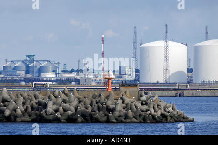 Porto di Mare con serbatoi di stoccaggio in background. Molo di cemento a fuoco in primo piano Foto Stock