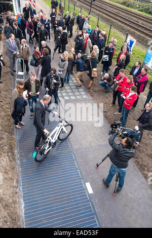 11/2014 Ministro olandese degli Affari economici Henk KAMP apre il primo al mondo pista ciclabile realizzata dalle celle solari in Krommenie, 25 chilometri a nord di Amsterdam. Normalmente l'apertura di una pista ciclabile è strettamente un affare locale nei Paesi Bassi. Questo è uno speciale: solo 70 metri (230 piedi) lungo, è il primo al mondo pista ciclabile realizzato da celle solari. Costruiti di lastre di cemento di 2,5 da 3,5 metri ( 6.5x10ft) con un traslucido lo strato superiore del vetro temprato con silicio cristallino celle solari al di sotto, si può produrre una quantità di energia sufficiente ad alimentare tre case. Foto Stock