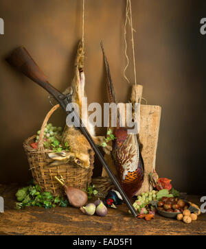 Classic still life con morti fagiani e lepri combinato con frutti autunnali e il fucile da caccia Foto Stock