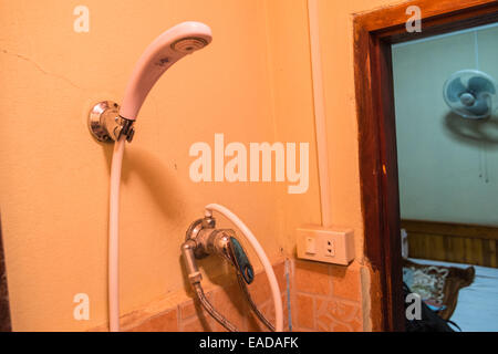 Pericolo.problema di salute e sicurezza. shock elettrico,presa elettrica di alimentazione nella sala da bagno con doccia.a buon mercato guest house a Luang Prabang, Laos, Asia. Foto Stock