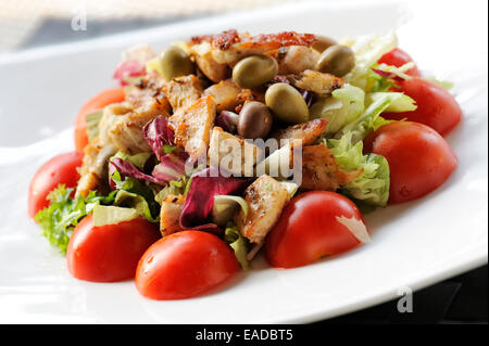 Con insalata di pollo, pomodori e olive su piastra Foto Stock