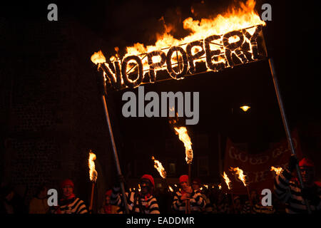 Notte dei falò Lewes, Sussex, 2014. Cliffe falò società membri marzo con un segno di masterizzazione dicendo "No Popery' Foto Stock