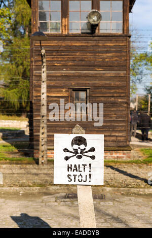 AUSCHWITZ, Polonia - 25 ottobre 2014: un segnale di avviso nella parte anteriore di un recinto elettrico nel campo di concentramento di Auschwitz Foto Stock