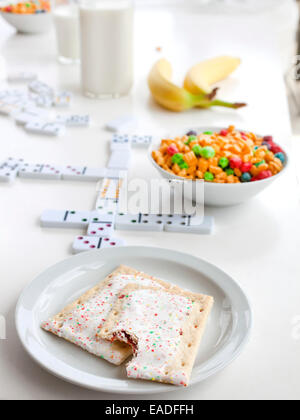 Crostate di pop e la colazione sul tavolo con giochi Foto Stock