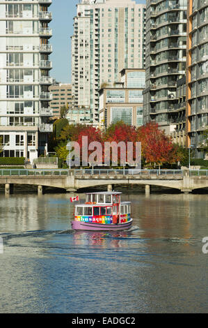 Vista nord di un acqua taxi viaggiano verso est su False Creek con i colori dell'autunno in background. Foto Stock