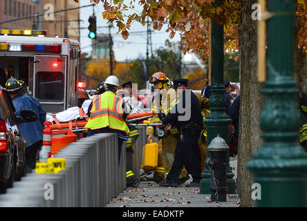 New York, Stati Uniti d'America. Xii Nov, 2014. I vigili del fuoco portano la finestra Rondelle per un ambulanza dopo il lavoro di salvataggio in una World Trade Center di New York, Stati Uniti, nov. 12, 2014. Due rondelle di finestra sono stati intrappolati per un'ora il mercoledì su una impalcatura penzolante high off il volto di One World Trade Center, l'edificio pi alto dell'emisfero occidentale. Fire equipaggi tagliare attraverso una finestra di sessantanovesima piano e delicatamente tirato dentro per la sicurezza. Credito: Wang Lei/Xinhua/Alamy Live News Foto Stock