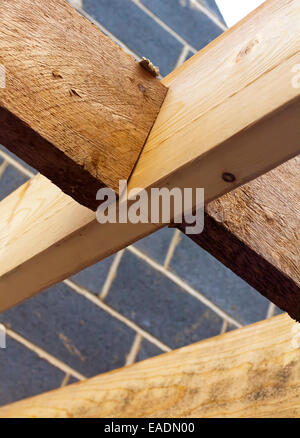 Dettaglio del tetto in legno travi su un cantiere dove una nuova casa viene costruita utilizzando legname e blocchi breeze Foto Stock