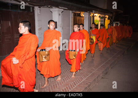 Monaci buddisti in una passeggiata molto presto elemosine con bocce di elemosina per ricevere, ricevere elemosine, cibo da devoti, Luang Prabang, Laos, Sud-est, Asia, Foto Stock