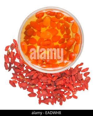La preparazione di goji berry tintura - sopra la vista di vetro con goji infusione di frutti di bosco e frutta secca isolati su sfondo bianco Foto Stock