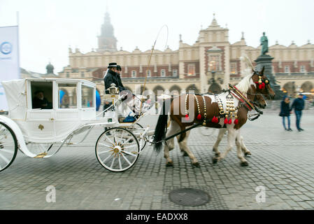 Cracovia in Polonia - 26 ottobre 2014: carrozza su Cracovia la piazza principale del mercato. In fondo è una città storica chiamata hall Foto Stock