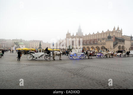 Cracovia in Polonia - 26 ottobre 2014: carrozza su Cracovia la piazza principale del mercato. In fondo è una città storica chiamata hall Foto Stock