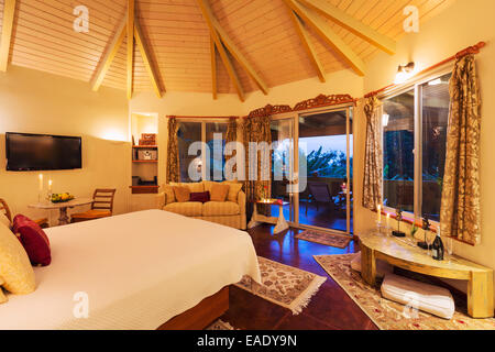 Romantica camera da letto accogliente con pavimenti in legno duro al tramonto. Home Interior Design Foto Stock