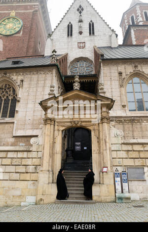 Cracovia in Polonia - 26 ottobre 2014: due uomini che indossano mantelli nero a guardia della porta della Basilica di San Stanislao e Vaclav o Wa Foto Stock