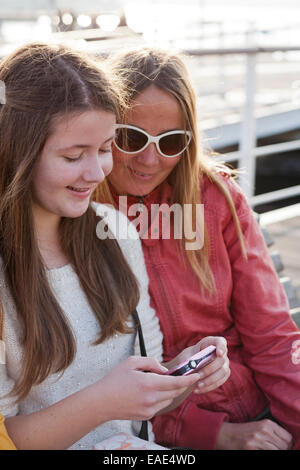 Le ragazze hanno divertente guardare le foto recentemente scattate. Foto Stock