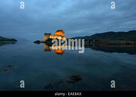 Eilean Donan Castle, sede ancestrale del clan scozzesi di Macrae, riflessa in Loch Duich in serata, Dornie, Highlands Foto Stock