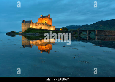 Eilean Donan Castle, sede ancestrale del clan scozzesi di Macrae, riflessa in Loch Duich in serata, Dornie, Highlands Foto Stock