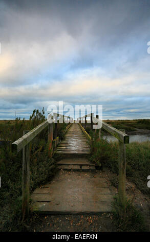 Ponte di legno su un torrente nelle paludi a Morston sulla Costa North Norfolk. Foto Stock