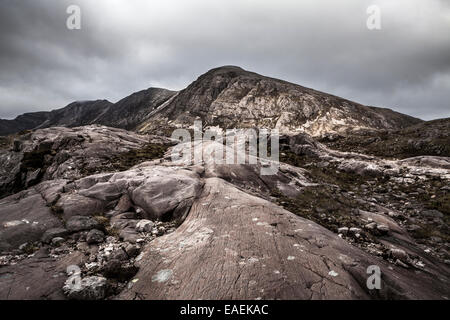 Vista del Beinn Liath Mor con un vasto ha segnato il lichen spotted lastra di pietra in primo piano Foto Stock