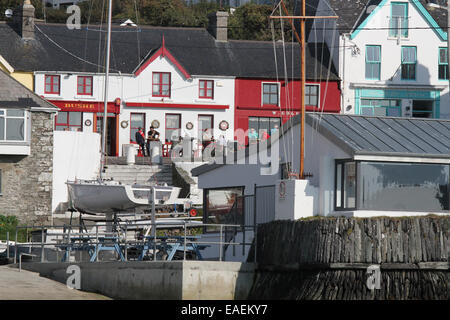 Le persone al di fuori di un pub in Irlanda al waterfront sopra il porto di Baltimore West Cork County Cork in Irlanda Foto Stock