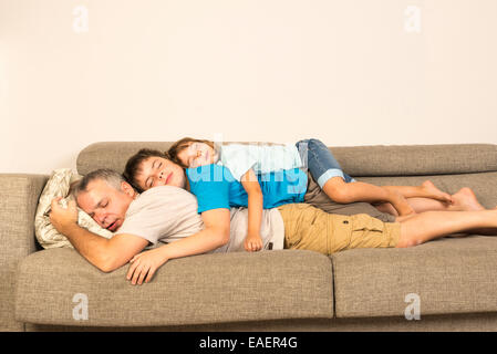 Padre e figlio sul divano distesa su ciascun altro Foto Stock