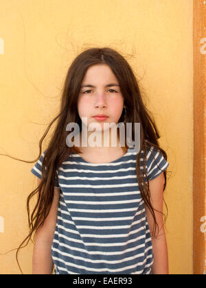 Ragazza giovane con espressione seria e capelli crespi Foto Stock