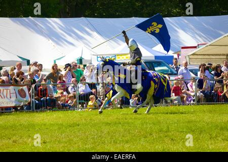 Un cavaliere a cavallo al galoppo round lo spettacolo anello. Cavalieri dei dannati giostre Display. Skelton Show, Cumbria, Inghilterra, Regno Unito. Foto Stock