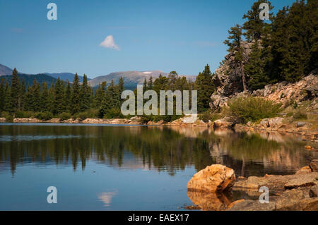 Una giornata di sole in Colorado Rockies con un cielo blu ed una nube riflettendo sul Lago di eco Foto Stock