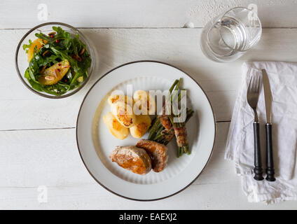 Medaglioni di maiale con patate e fagioli avvolto in pancetta Foto Stock