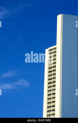 Costruzione di dettaglio: Ampia angolazione di un alto edificio contro un cielo blu la creazione di angoli interessanti e motivi geometrici. Foto Stock