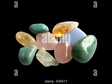 Semi-preziose pietre preziose in giallo, verde e rosa, isolati su nero. Quarzo, aventurine, calcite citrino e altri. Foto Stock