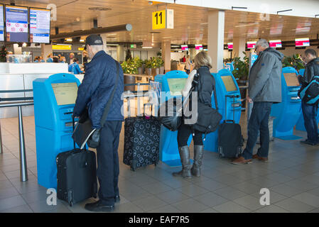 I viaggiatori in automatico di check-in presso l'aeroporto di Schiphol di Amsterdam Olanda Foto Stock