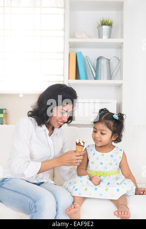 Indian madre e bambino godendo di gelato indoor Foto Stock