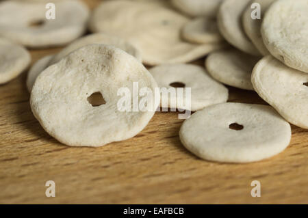 Il round cockleshells sparsi su una superficie di legno, close up Foto Stock