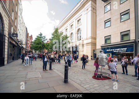 LONDON, Regno Unito - 5 giugno 2014: folle raccogliere su una soleggiata giornata di primavera in Covent Garden come gli artisti di strada esibirsi in Foto Stock